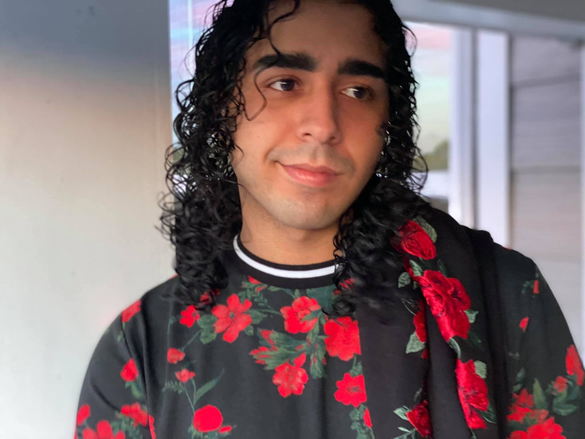 hispanic person in black shirt with a red rose print