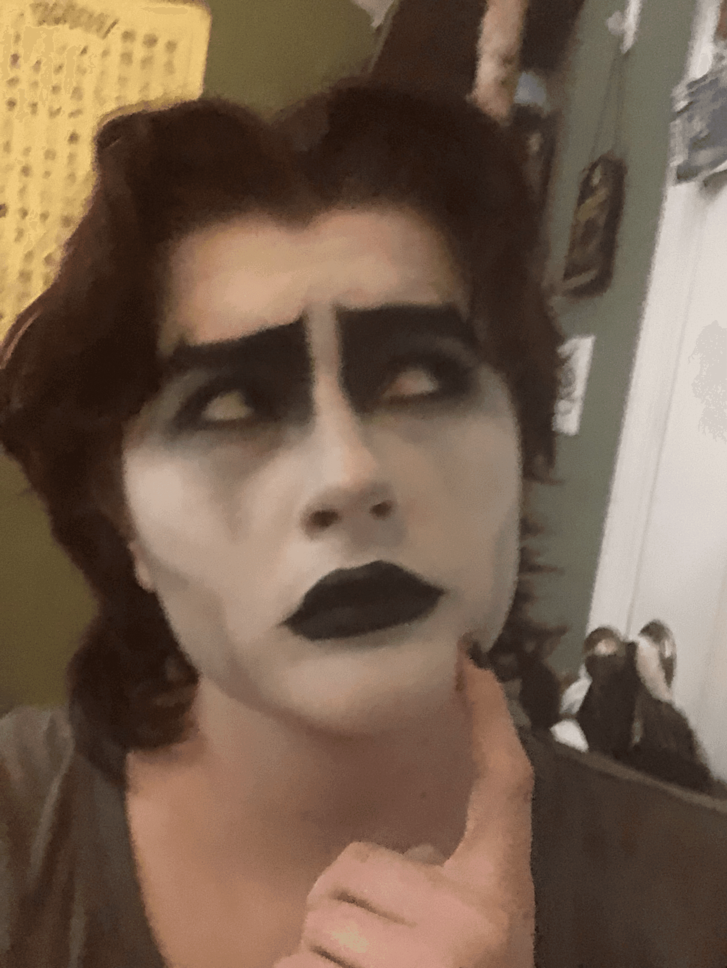 girl with brown hair in gothic makeup curiously looking upward